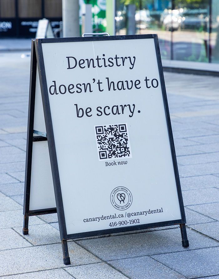 Canary Dental sidewalk sign with QR code and message “Dentistry doesn’t have to be scary”